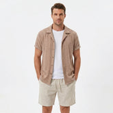 Man wearing a coffee brown floral checkerboard jacquard Cuban shirt and linen cotton drawstring shorts front view