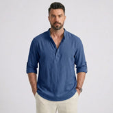 Man wearing MannerCo denim blue cotton linen long sleeve Henley shirt with stand collar, front view