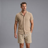 Man wearing a navy geometric jacquard button up shirt and crinkle textured shorts front view on plain background