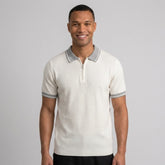Man wearing a white color block knit polo shirt with lapel collar front view on plain background