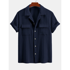 Navy pleated shirt on a hanger with a white background