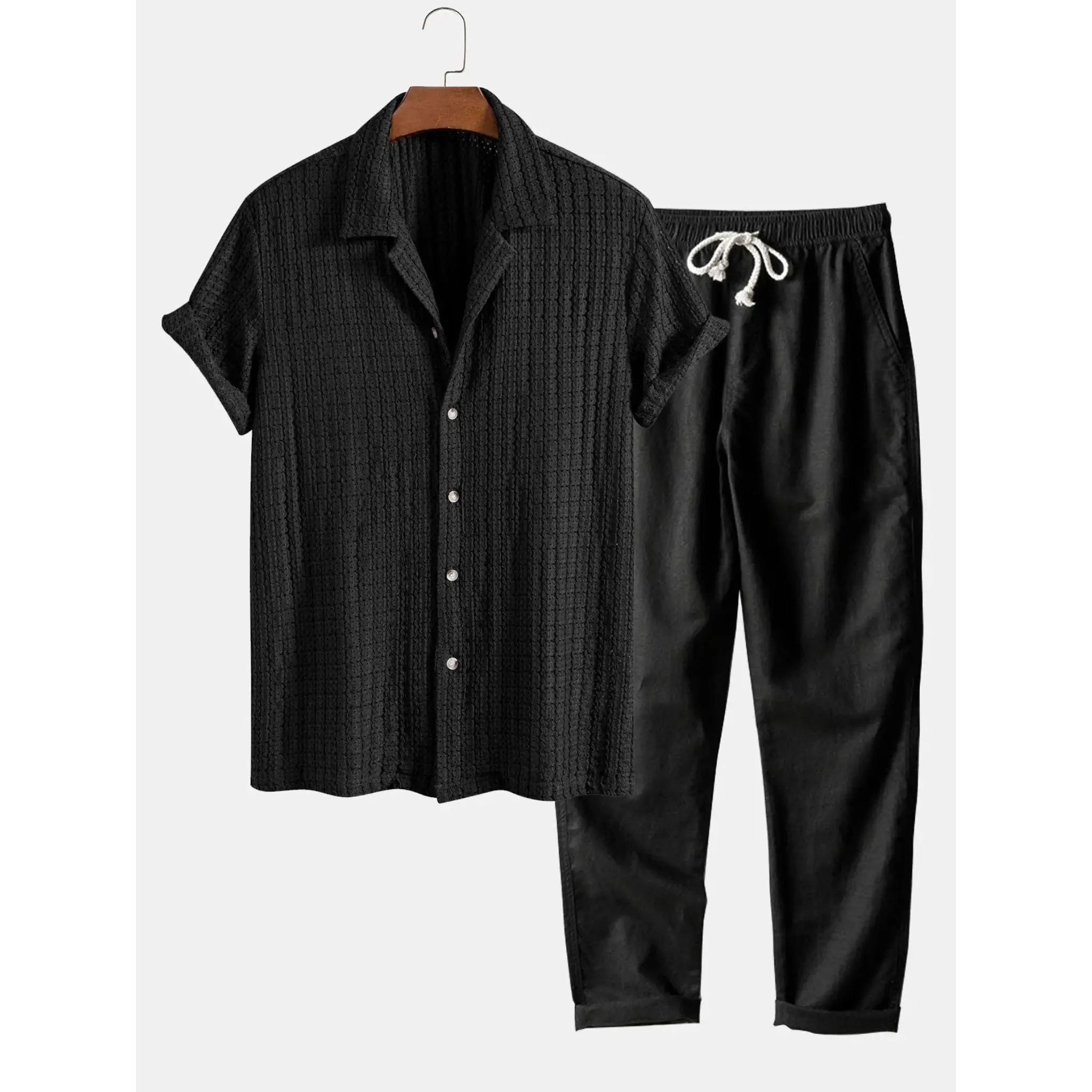 Black shirt and pants set on a hanger against a white background