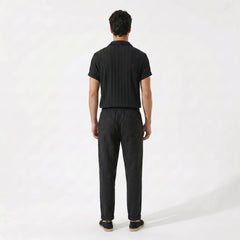 Back view of man wearing a black outfit with a white background