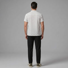 Back view of man wearing a white striped shirt and black pants on a gray background