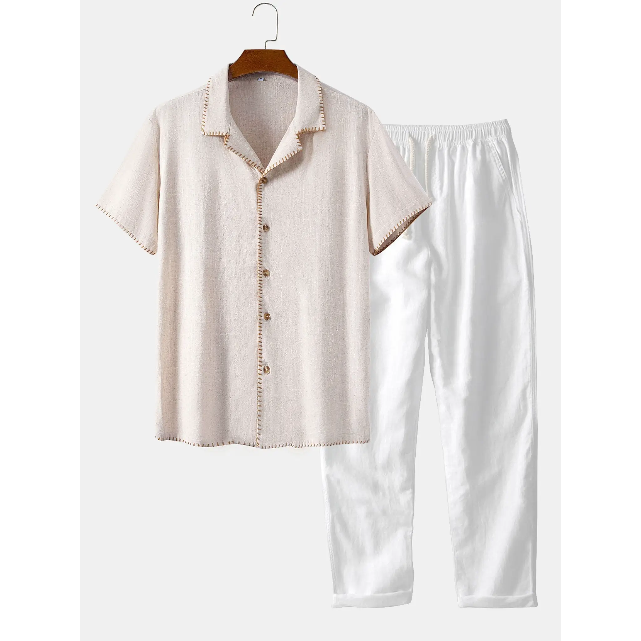 Beige shirt and white pants set on a hanger against a white background