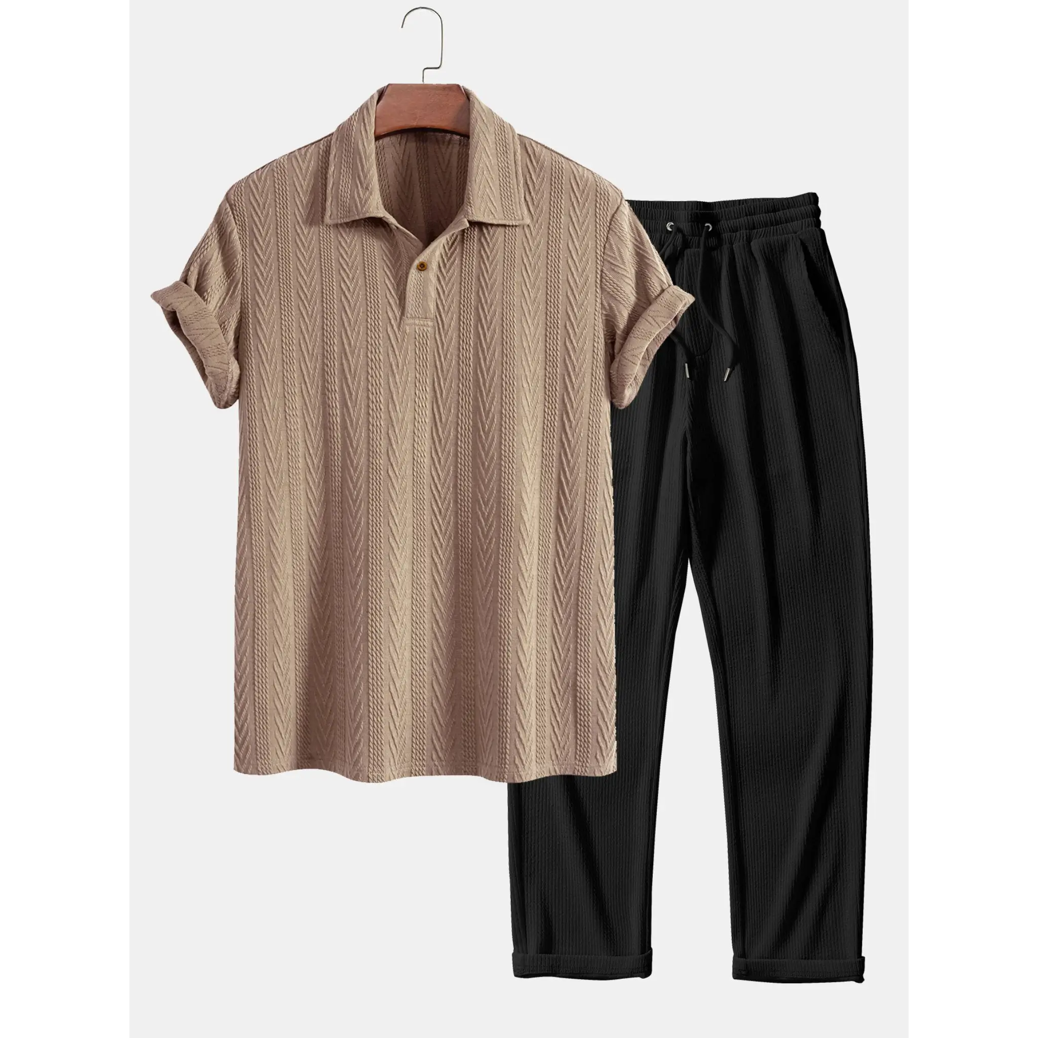 Beige short-sleeve shirt and black pants on a hanger against a white background