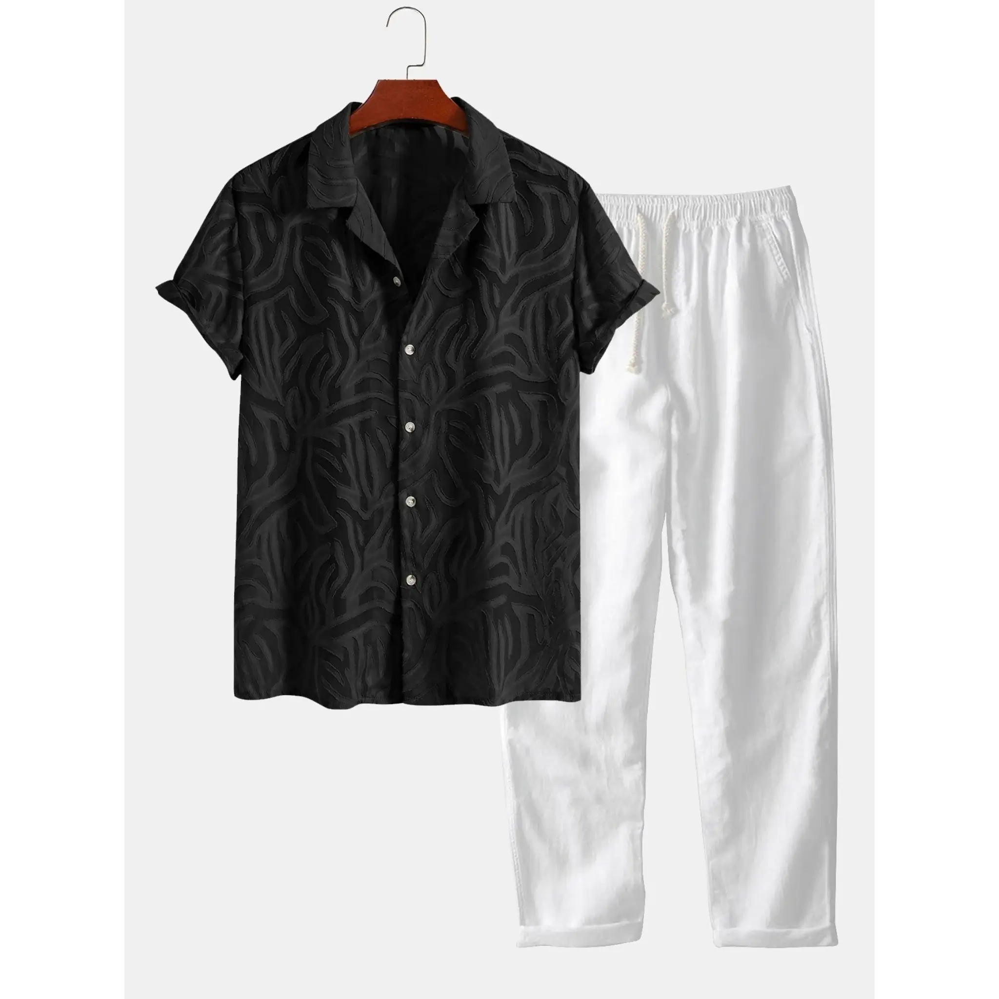 Black patterned shirt and white pants on a hanger against a white background