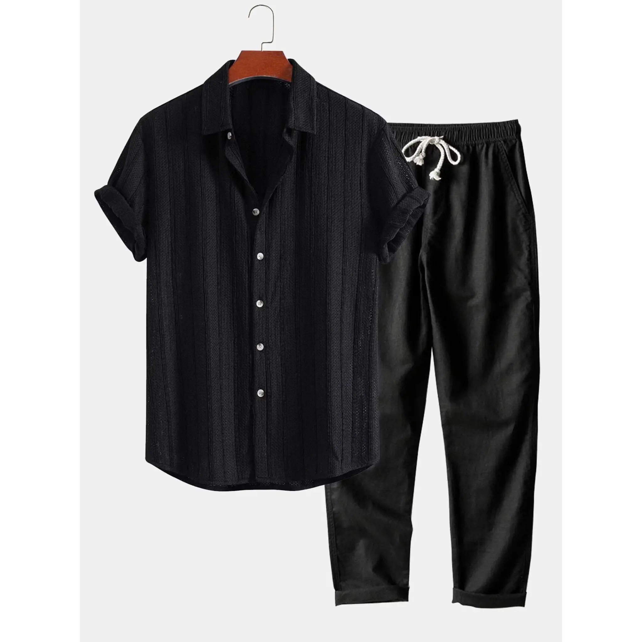 Black shirt and pants set on a hanger against a white background