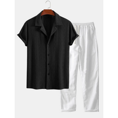 Black shirt and white pants on a hanger against a white background