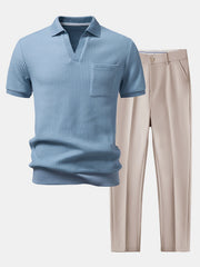 Blue textured polo shirt and beige pants on a light gray background