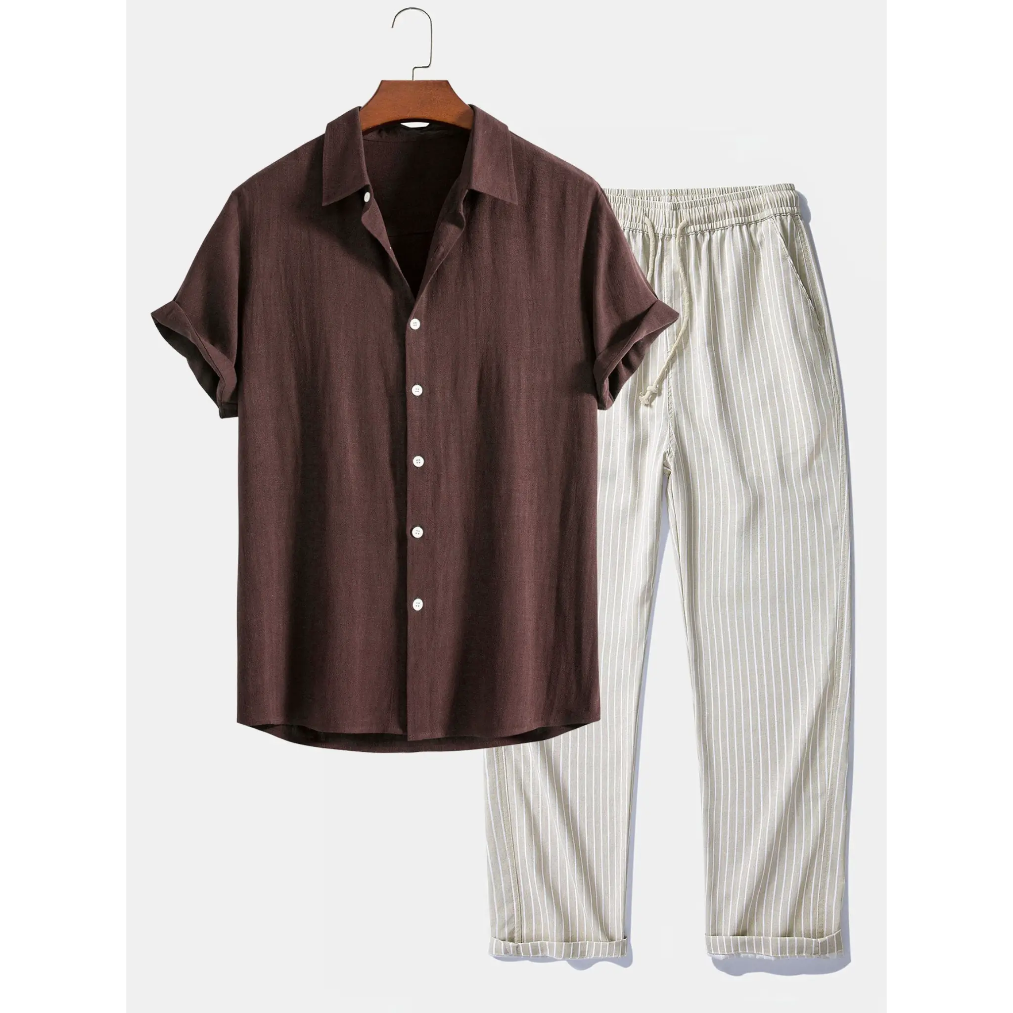 Brown shirt and white striped pants on a hanger against a white background