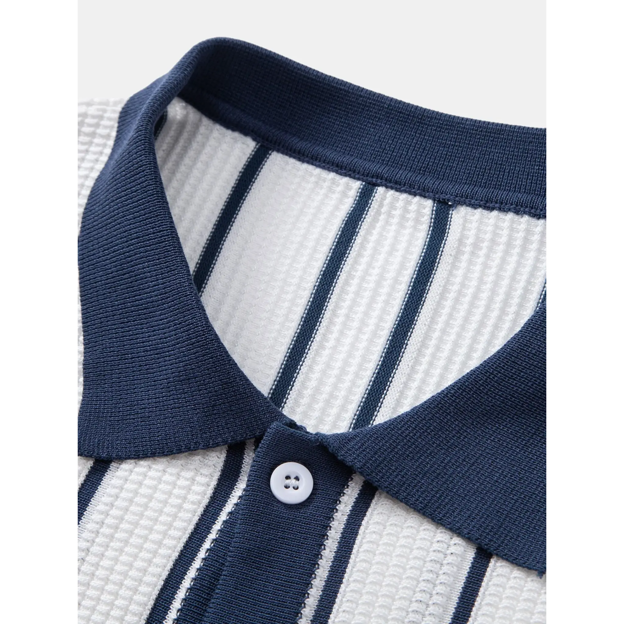 Close-up of a blue and white striped shirt collar with a button.