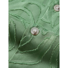 Close-up of green jacquard fabric texture with button