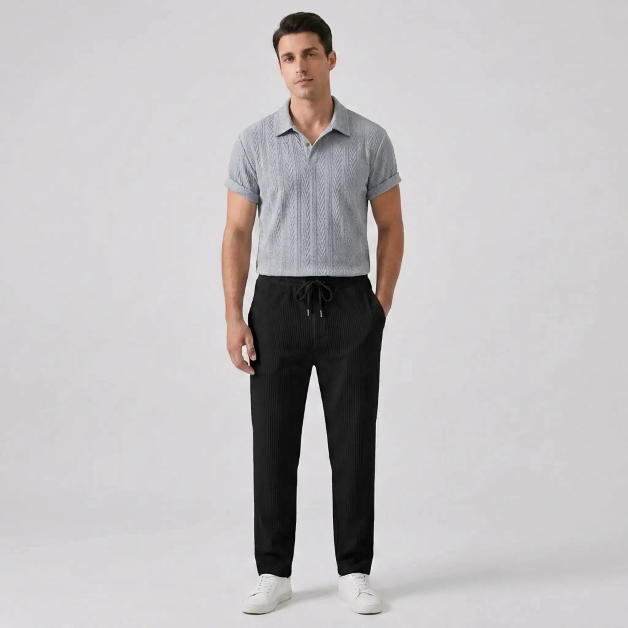 Front view of man wearing silver polo shirt and pants set on a white background
