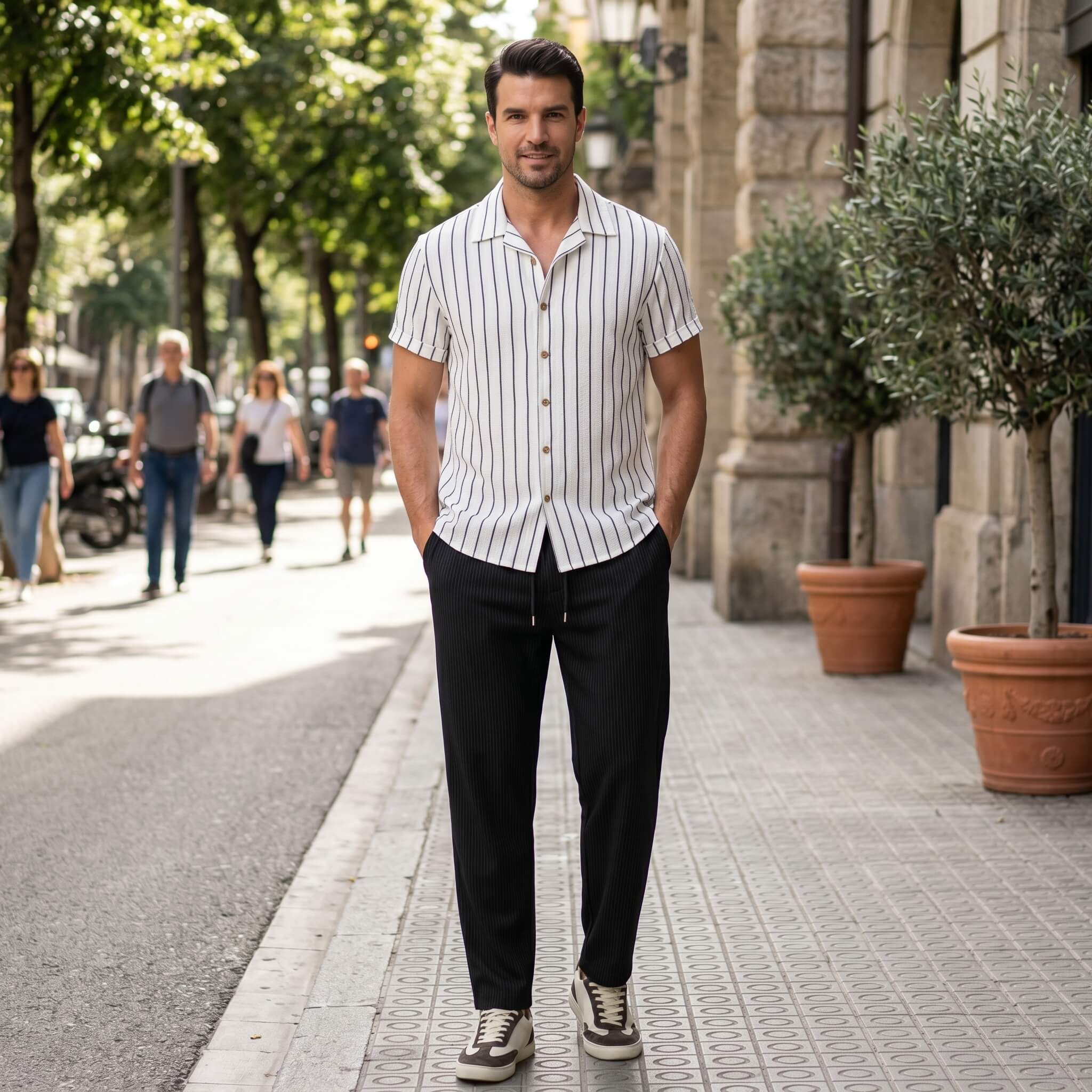 Man in a striped shirt and black pants standing on a city street