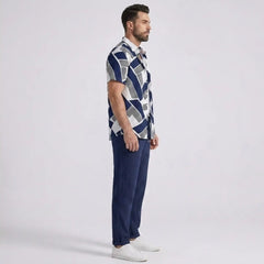 Man side view wearing a patterned shirt and navy pants on a white background