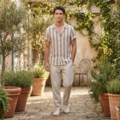 Man standing in a garden with potted plants and a stone path