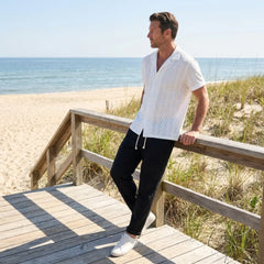 Man standing on a wooden deck by the beach