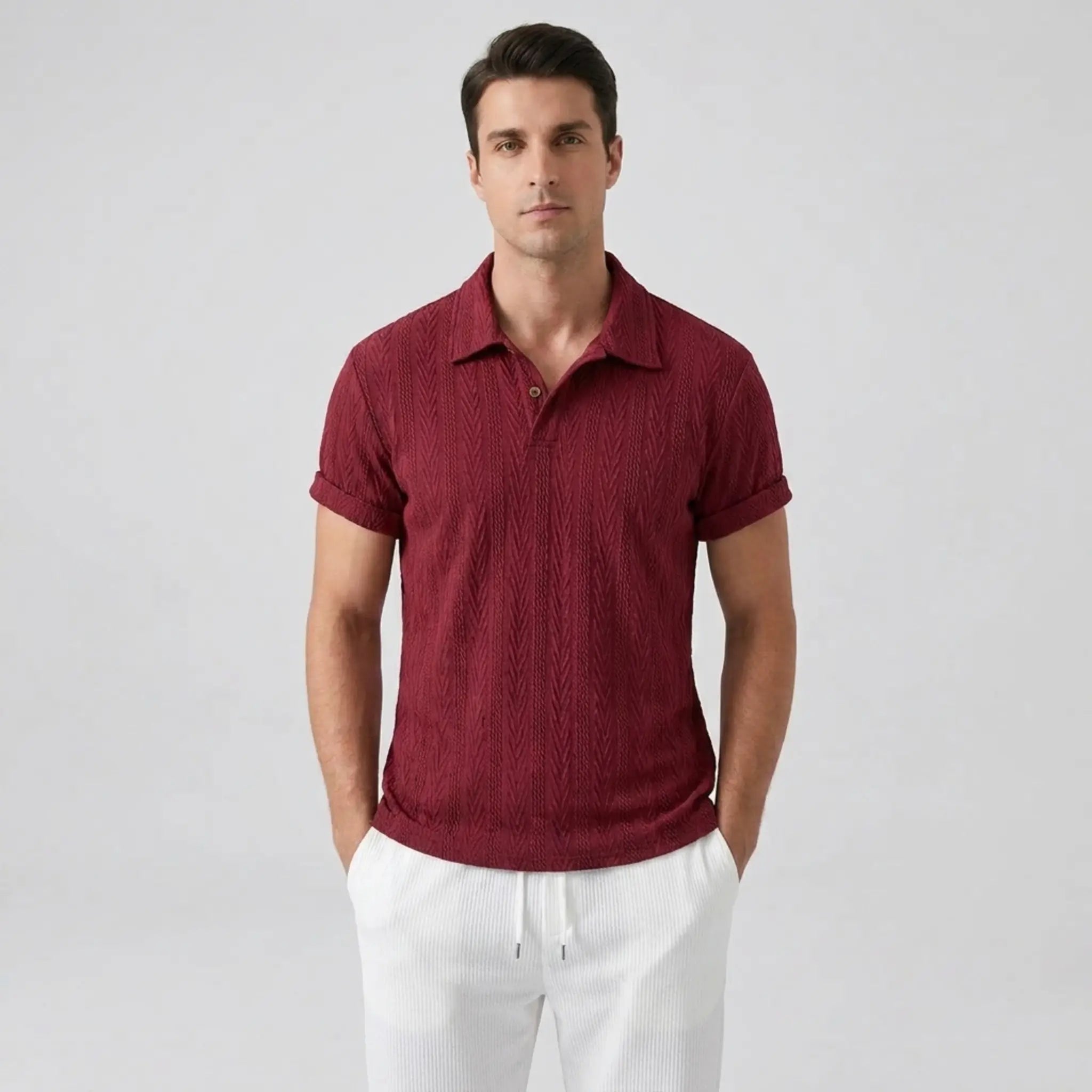 Man wearing a Maroon textured polo shirt and white pants on a light gray background