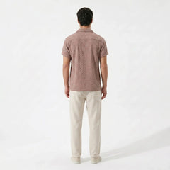 Man wearing a Tan polo shirt and beige pants on a white background
