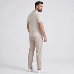 Man wearing a beige polo shirt and pants on a white background