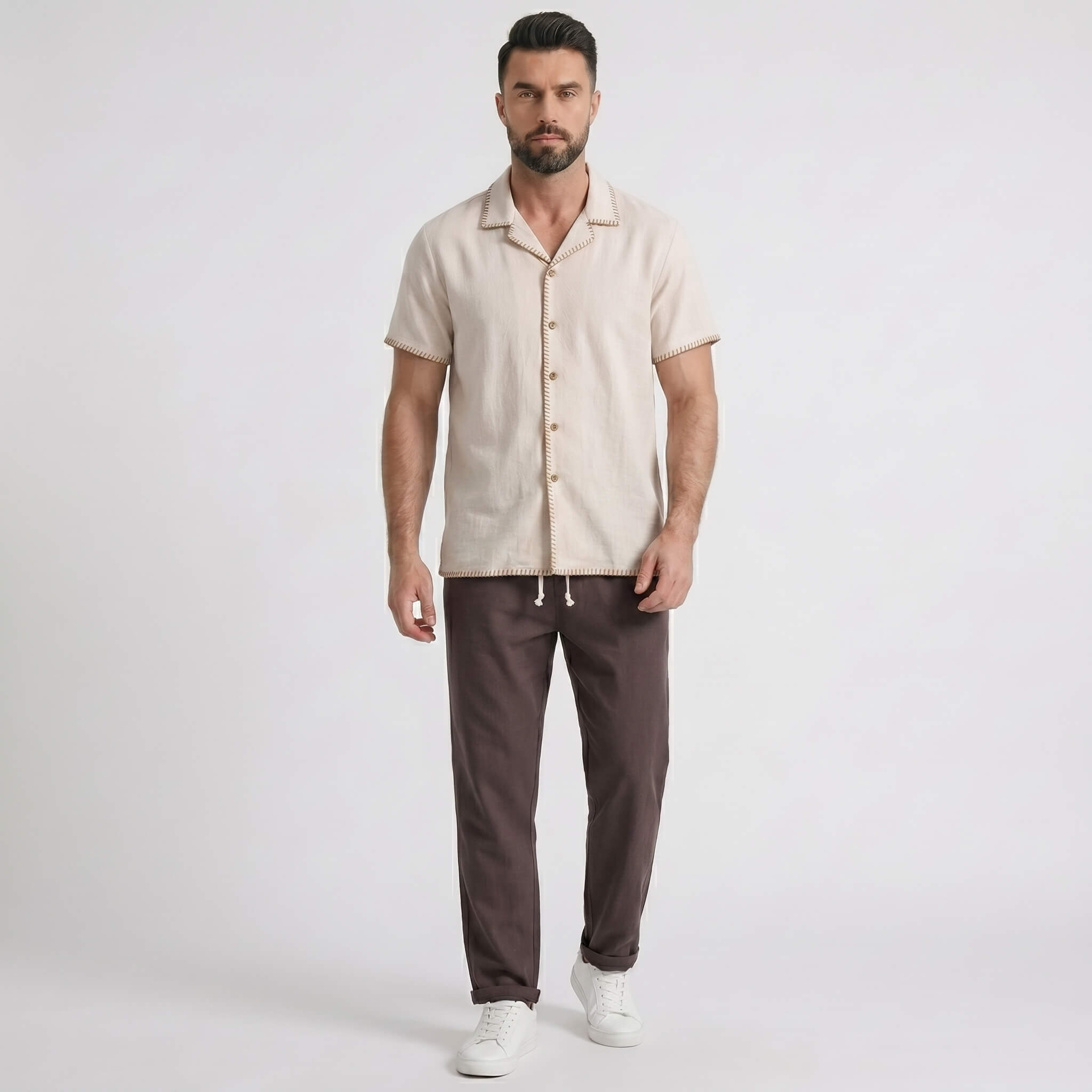 Man wearing a beige shirt and coffee pants on a white background