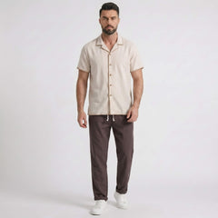 Man wearing a beige shirt and coffee pants on a white background