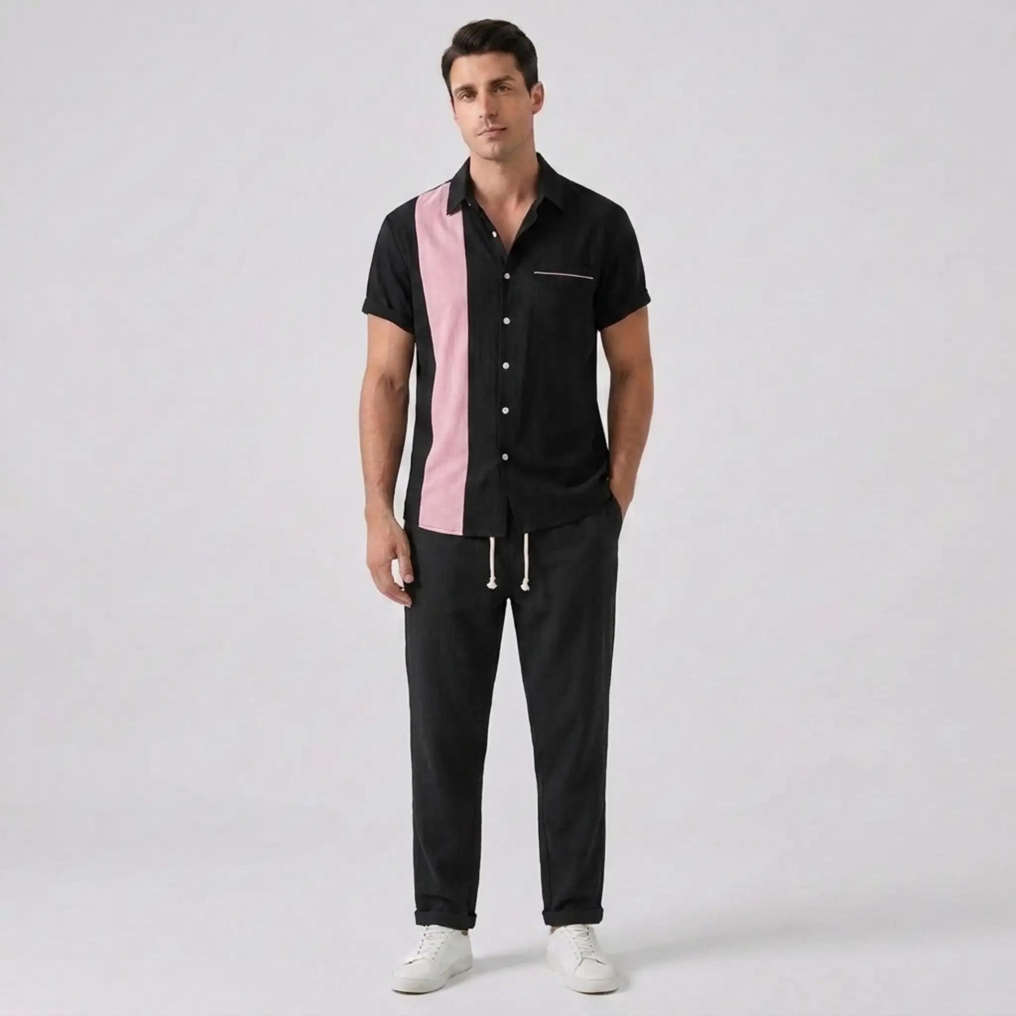 Man wearing a black and pink shirt with black pants on a white background