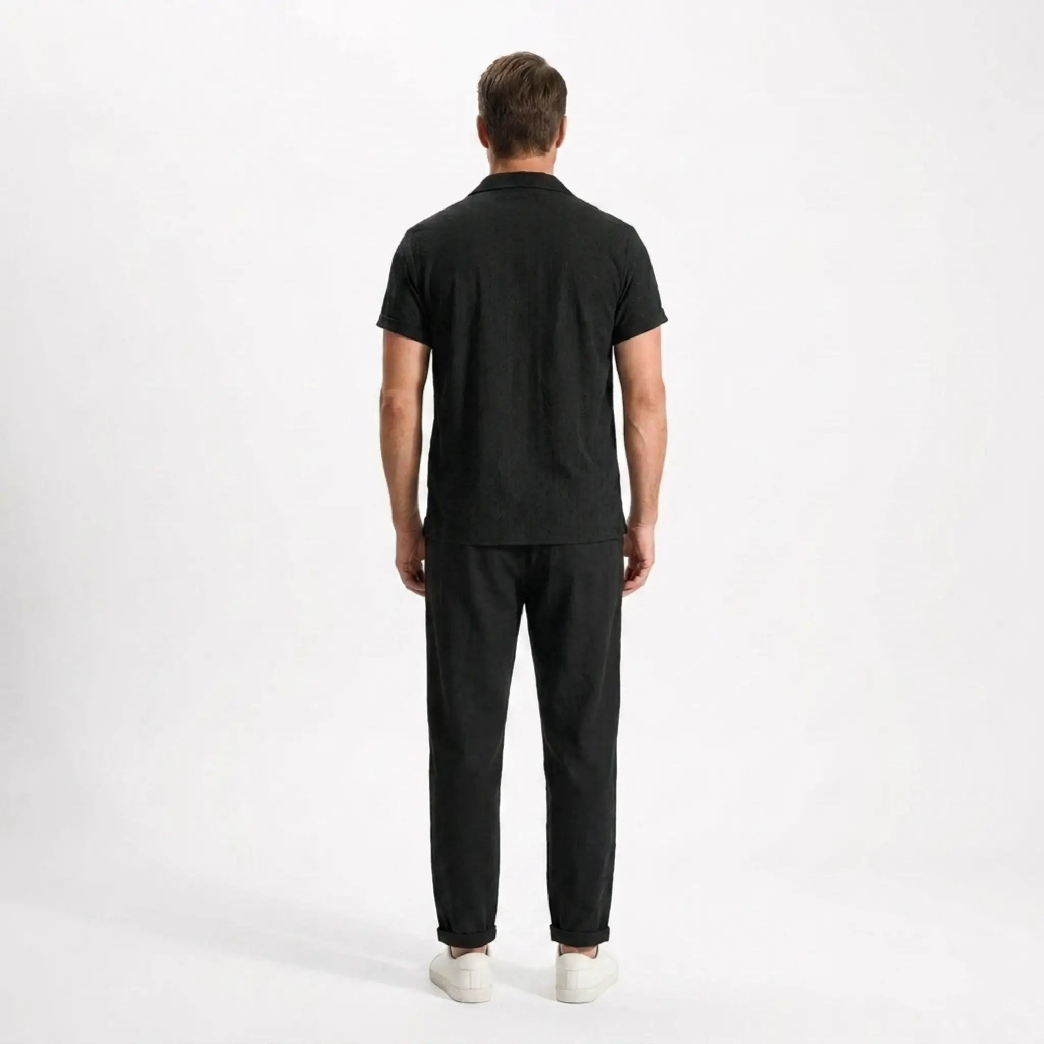 Man wearing a black outfit on a white background