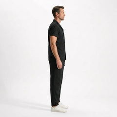 Man wearing a black outfit side view on a white background