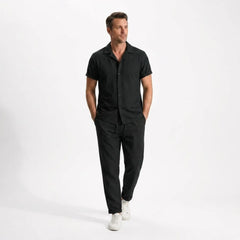 Man wearing a black outfit with white shoes on a white background