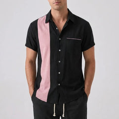 Man wearing a black shirt with a pink panel on a white background