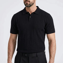 Man wearing a black short-sleeve shirt against a light gray background