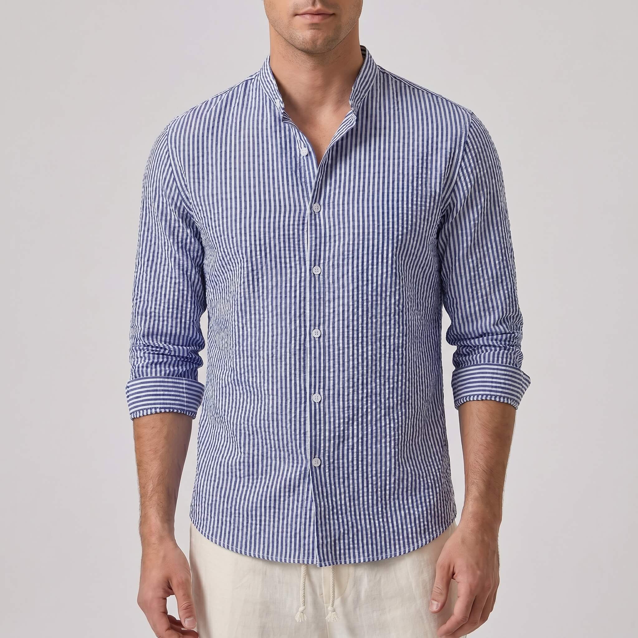 Man wearing a blue and white striped shirt on a plain background