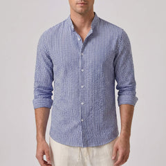 Man wearing a blue and white striped shirt on a plain background