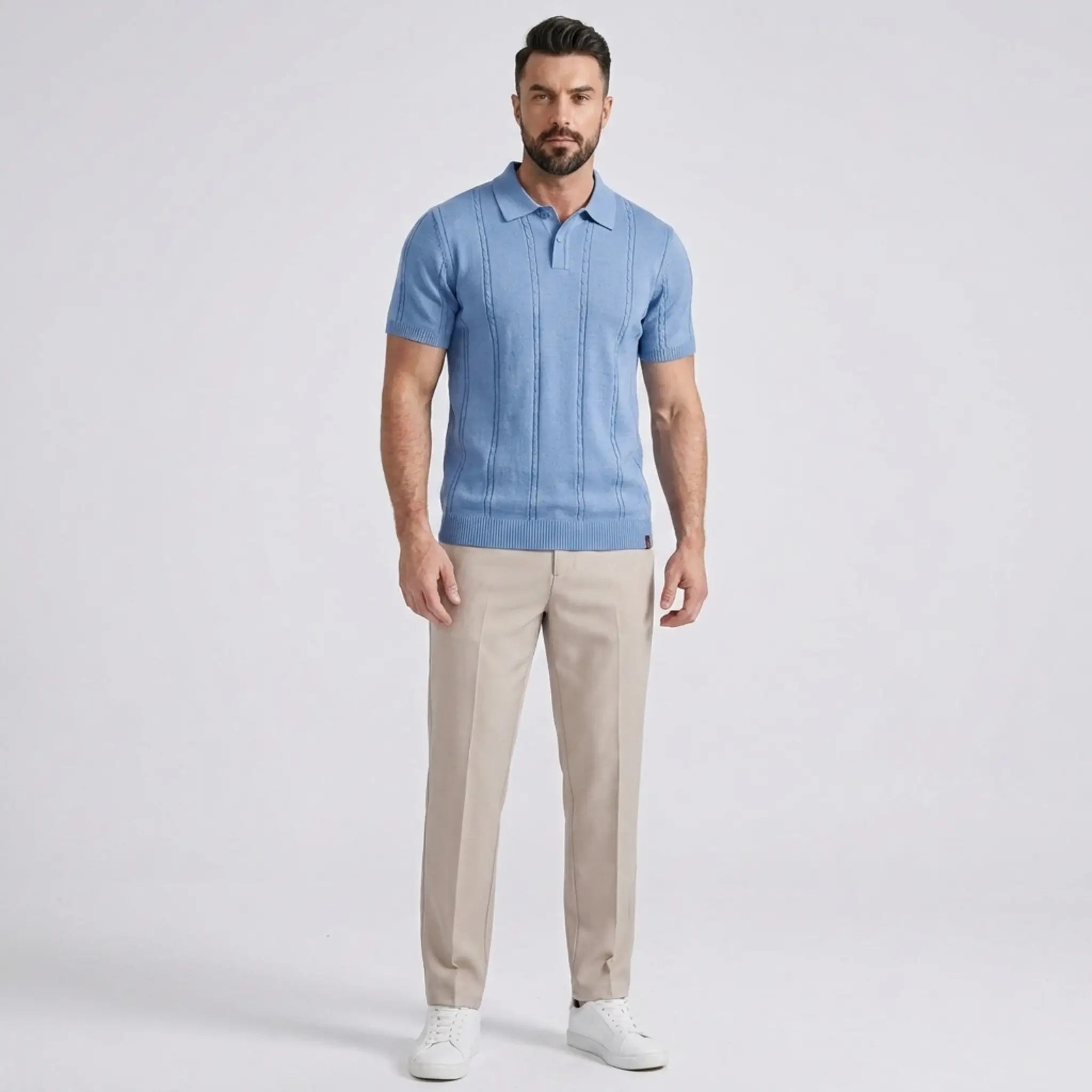 Man wearing a blue polo shirt and beige pants on a light gray background