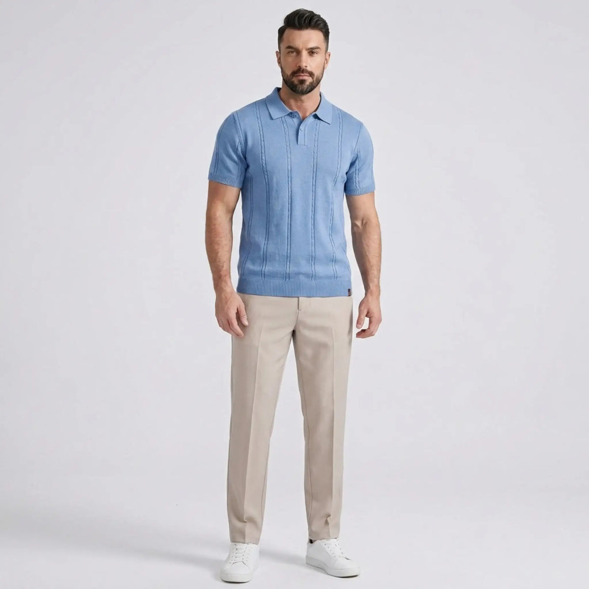 Man wearing a blue polo shirt and beige pants on a light gray background
