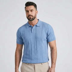 Man wearing a blue short-sleeve shirt against a light gray background