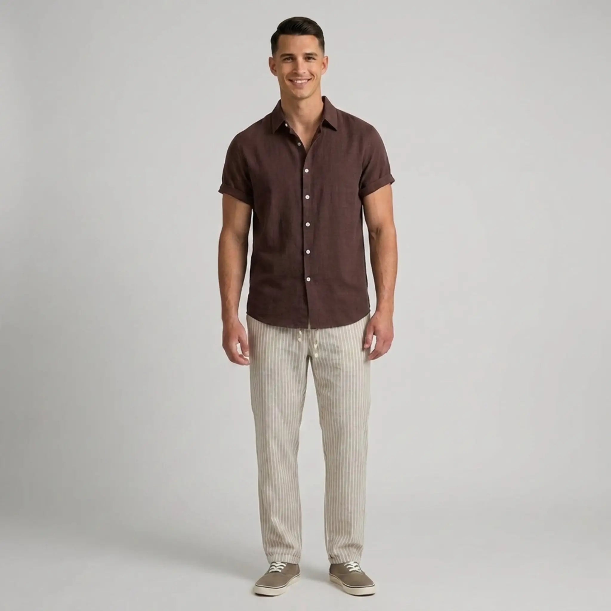 Man wearing a brown shirt and beige pants on a gray background