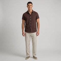 Man wearing a brown shirt and beige pants on a gray background