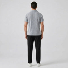 Man wearing a gray patterned polo shirt and black pants back view on a white background