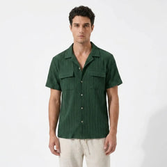 Man wearing a green shirt and beige pants front shirt view on a white background