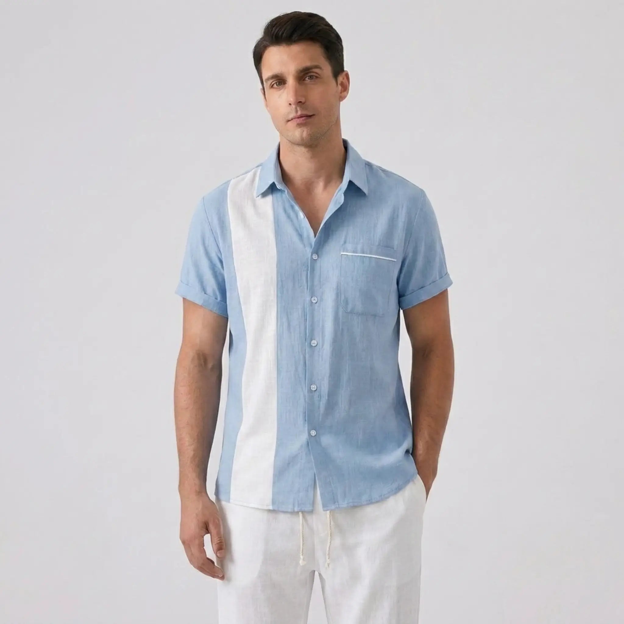 Man wearing a light blue and white checkered shirt with white pants on a gray background