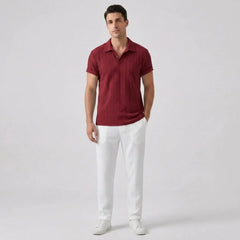 Man wearing a maroon polo shirt and white pants front view on a light gray background