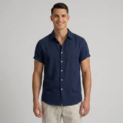 Man wearing a navy blue short-sleeve shirt on a gray background