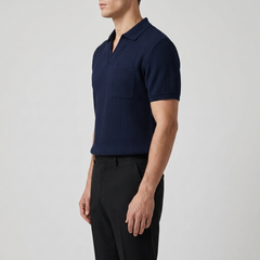 Man wearing a navy ribbed short-sleeve shirt and black pants on a light gray background
