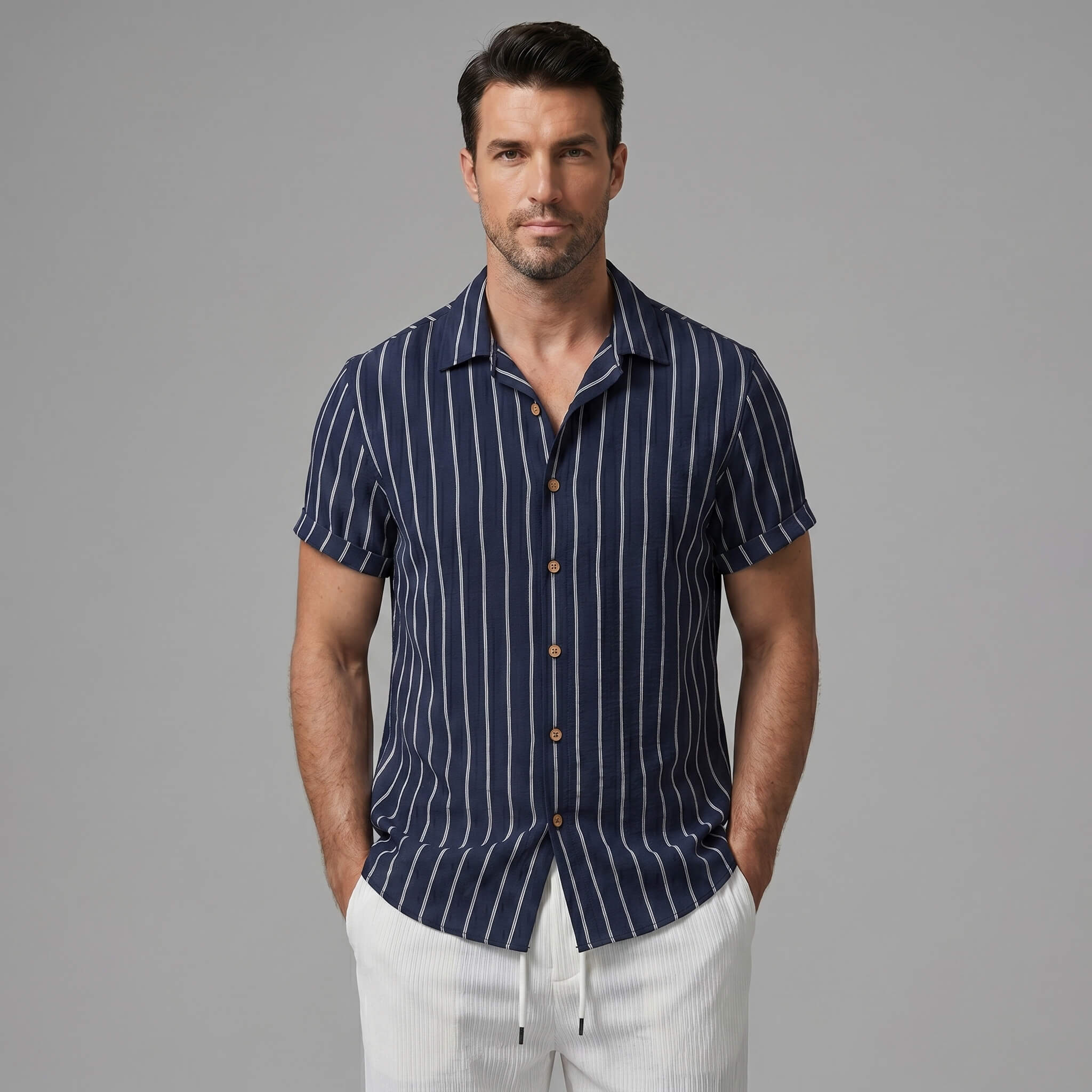 Man wearing a navy striped shirt with brown buttons on a gray background