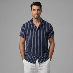 Man wearing a navy striped shirt with brown buttons on a gray background