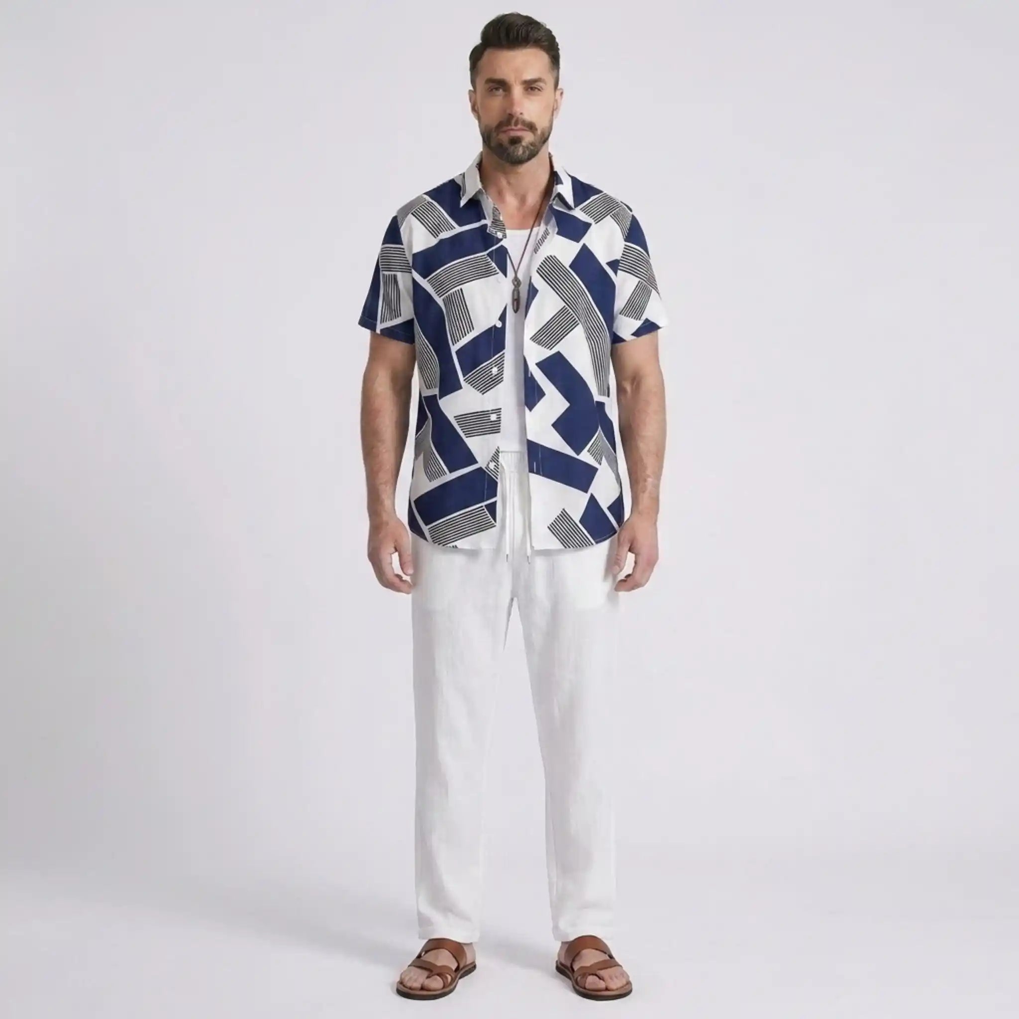 Man wearing a patterned shirt and white pants on a light gray background