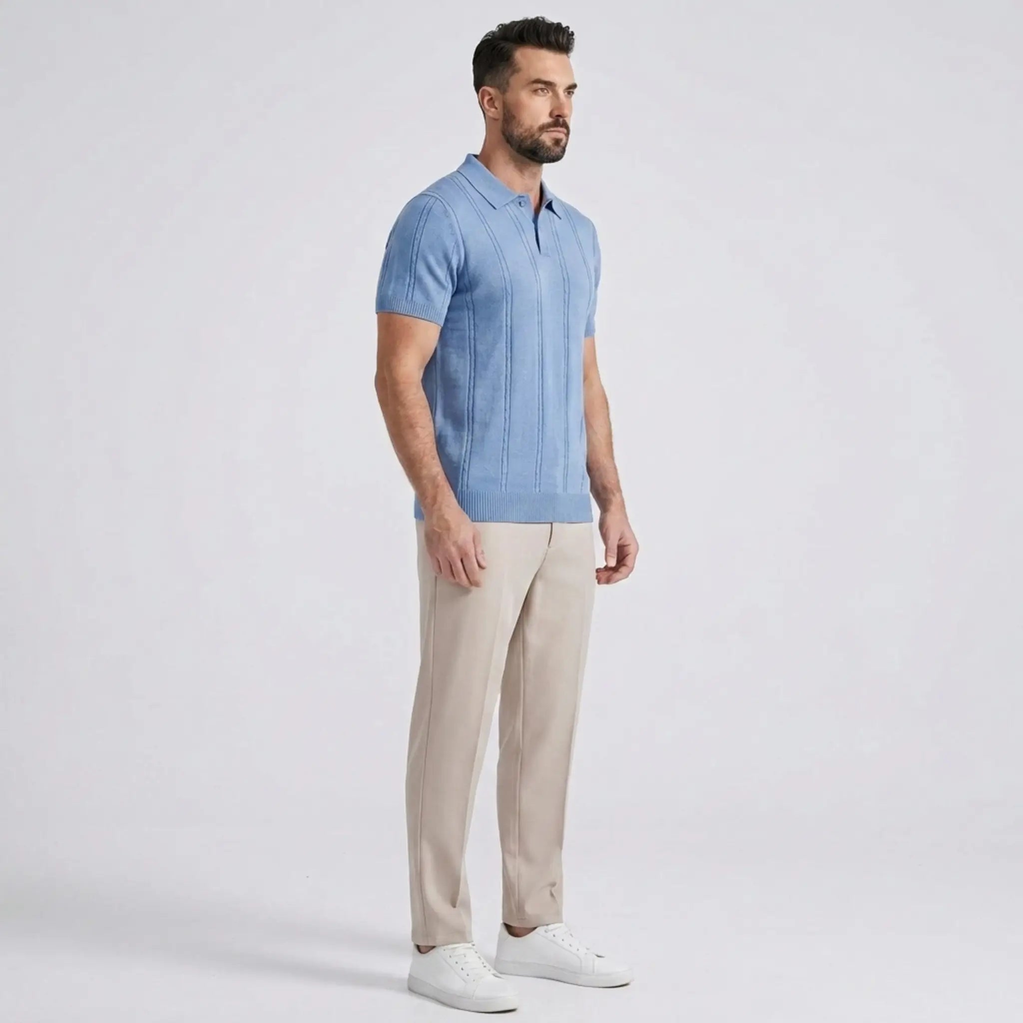 Man wearing a sky blue shirt with beige pants on a gray background